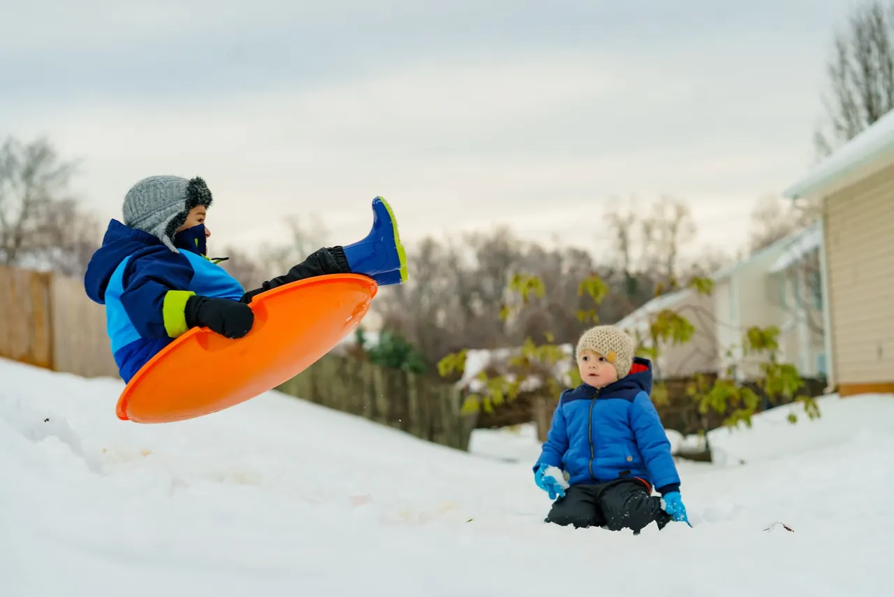 Kinder beim Rodeln im Schnee